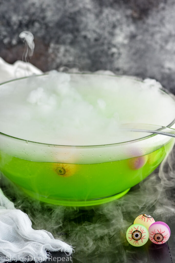 punch bowl of Halloween Punch with smokey dry ice, ladle and eye ball garnish