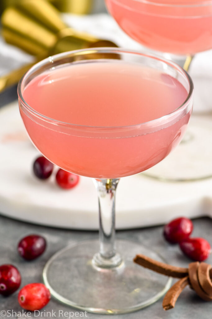 Glass of cranberry daiquiri with cranberries laying beside