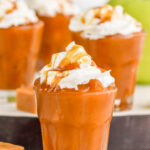 Photo of Caramel Apple Pudding Shots garnished with whipped cream and caramel.