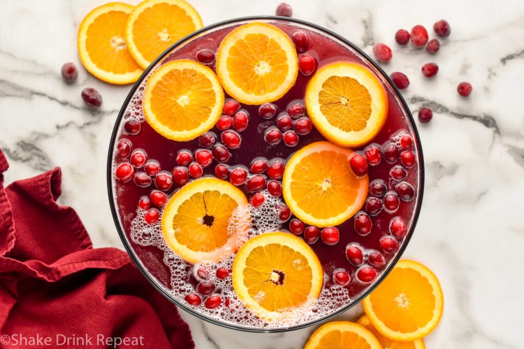 overhead view of bowl of Christmas Punch garnished with orange slices and cranberries