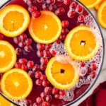 overhead view of bowl of Christmas Punch garnished with orange slices and cranberries