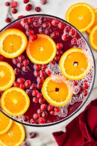 overhead view of bowl of Christmas Punch garnished with orange slices and cranberries