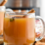 mug of spiced apple cider garnished with a cinnamon stick and star anise