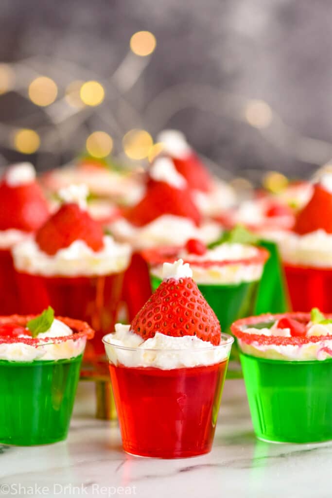 Photo of Santa Hat Jello Shots and green christmas shots with sparkling lights in the background