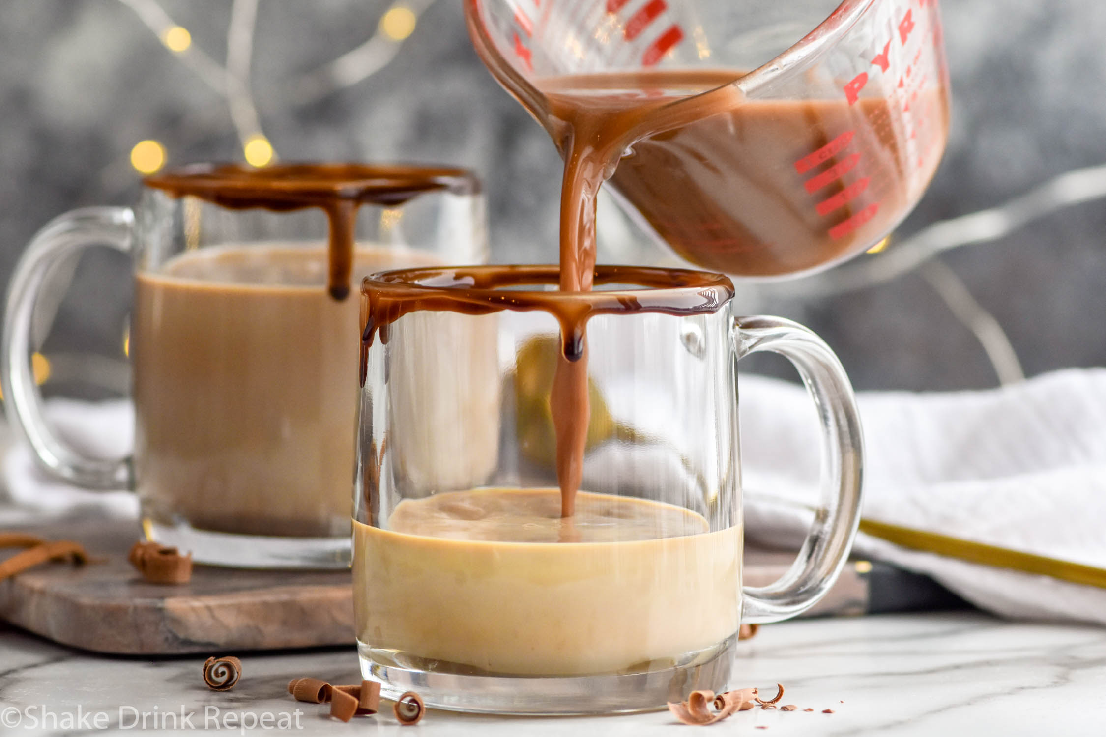 Front facing photo of Dirty Snowman with chocolate liqueur being poured into the glass mug.