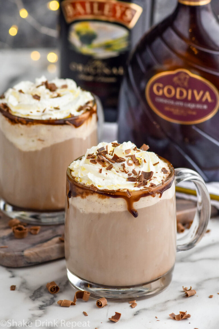 Overhead photo of Dirty Snowman Drink with two glasses of the drink and baileys and Godiva bottles in the background.