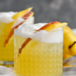 Front facing photo of Apple Pear Whiskey Sour with egg white foam and apple and pear slices.