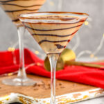 Front facing photo of Chocolate Martini in a chocolate drizzled martini glass with another martini behind it.