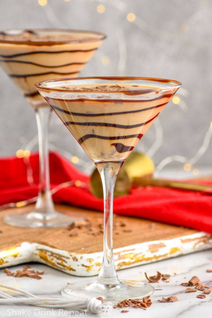 Front facing photo of Chocolate Martini in a chocolate drizzled martini glass with another martini behind it.