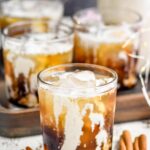 Overhead front facing photo of Eggnog White Russian in a glass Tumblr with a cinnamon stick next to it.