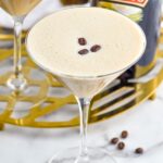 Overhead photo of two Baileys Espresso Martinis garnished with three coffee beans. Bottle of Baileys in the background.