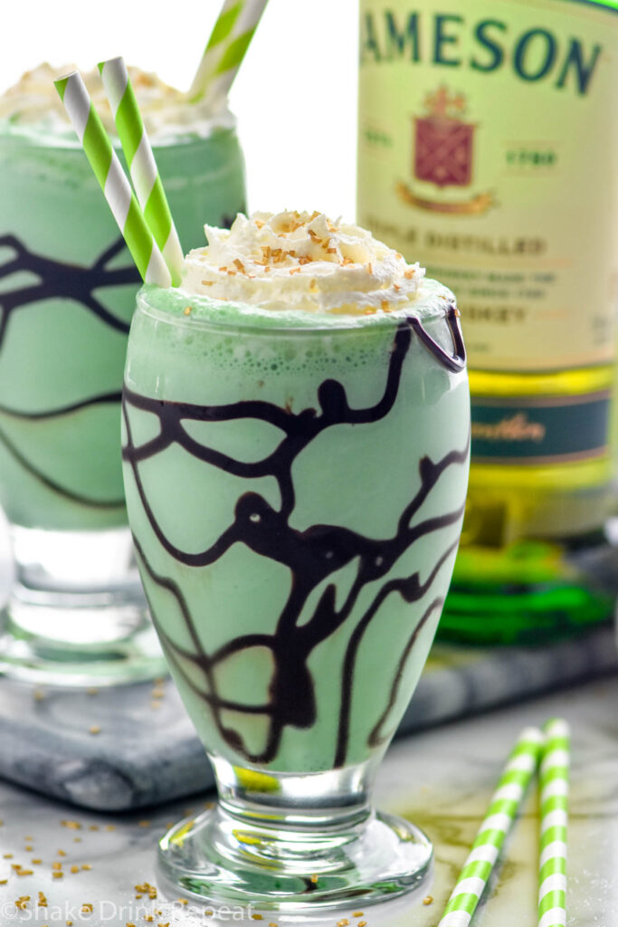 Close up photo of two St. Patrick's Day mudslides. Bottle of Jameson in the background.
