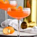 Photo of Paper Plane cocktails garnished with an orange peel.