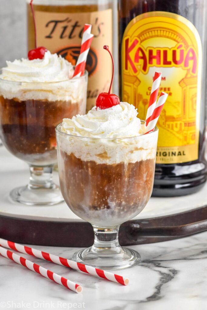 Overhead photo of White Russian Floats. Bottles of Tito's and Kahlua in the background.