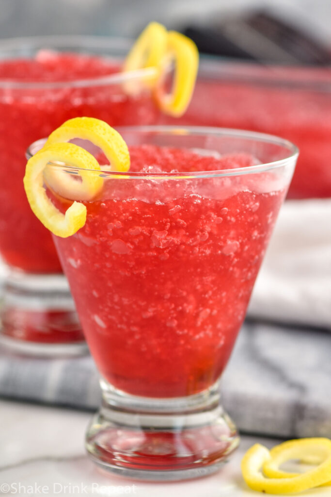 Side view of Frozen Cosmo garnished with lemon twist.