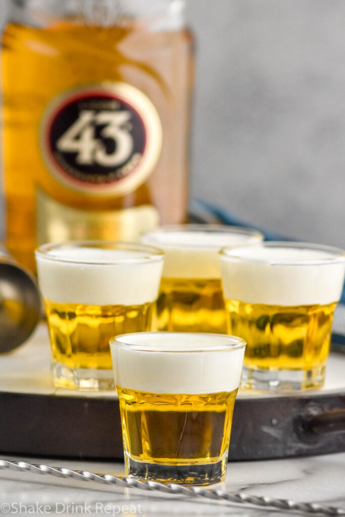 Side view of Mini Beer Shots with Licor 43 in the background.