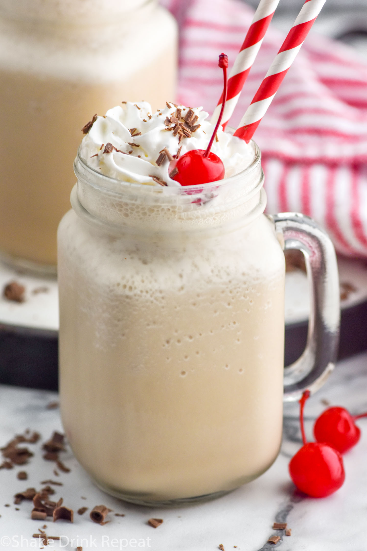 Photo of Bushwacker cocktail served in a glass mug garnished with cherries and straws