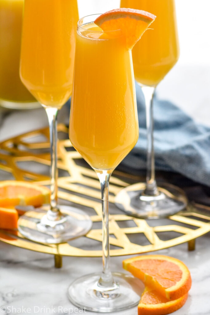 Non Alcoholic Mimosas on a platter with orange slices beside