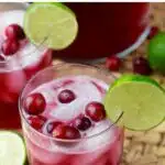 Pinterest graphic for cranberry beergarita. Text says "the best cranberry beergarita shakedrinkrepeat.com" Image shows two glasses of cranberry beergarita with ice and lime wedges.
