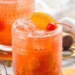 Cherry Old Fashioned garnished with orange slices and cherries