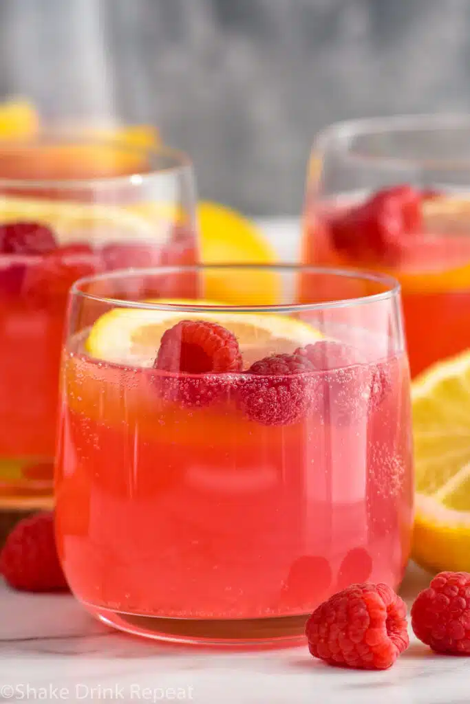 Side view of Pink Lemonade Vodka Punch with raspberries and lemon slices