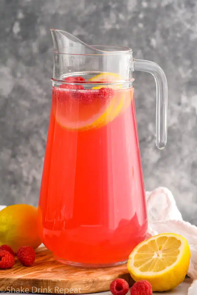 Pitcher of Pink Lemonade Vodka Punch with lemons and raspberries
